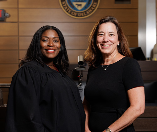 A mentor and a student standing and smiling